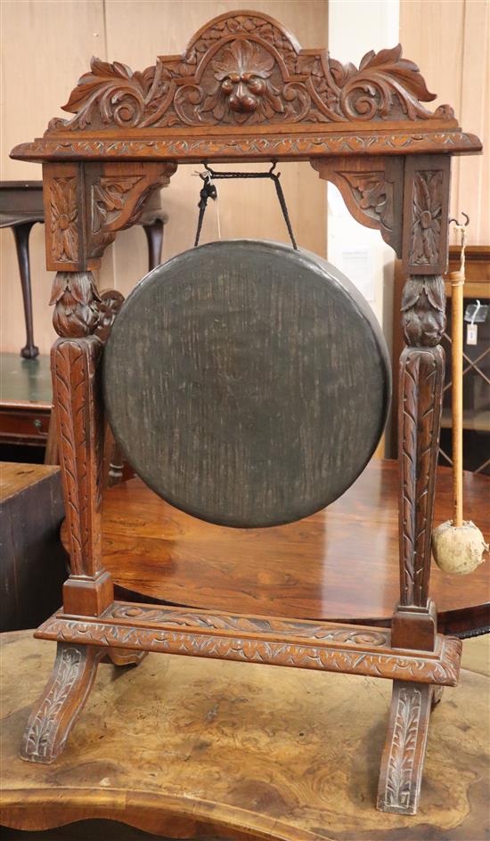 A late 19th century Flemish carved oak dinner gong, with striker H.100cm